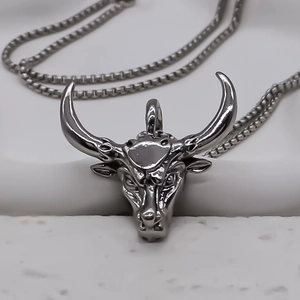 Vue macro d'un pendentif tête de taureau gris foncé avec chaîne à mailles carrées