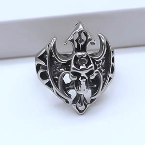 Gros plan d'une bague gothique tête de mort avec ailes tribales en argent antique