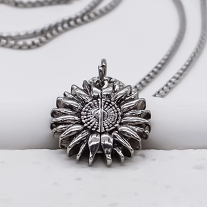 Détail du pendentif tournesol vintage avec pétales texturés et chaîne à maillons