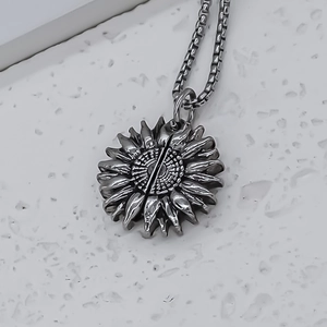 Vue macro d'un pendentif tournesol argenté vintage avec des pétales gravés