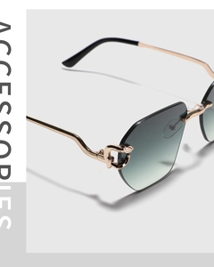 Detail of rimless sunglasses with green gradient lens and gold leopard head hinge