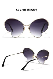 Détail des lunettes papillon en métal avec verres dégradés gris et monture dorée