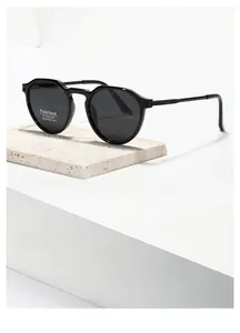 Detail view of TR7017 black polarized sunglasses with UV400 lenses on travertine stone