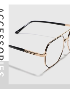 Detailed close-up of double-bridge black and gold metal eyeglass frames with engraving