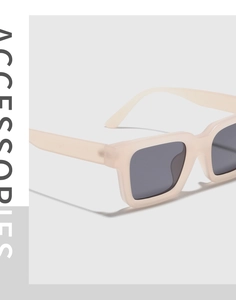 Close-up of modern rectangular cream sunglasses with wide temples and dark gray lenses