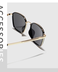 Detail showing high-quality gold metal frame and black polarized lenses on square sunglasses