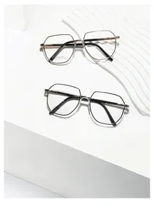 Detailed macro view of gold and black polygonal metal glasses frames on a textured base