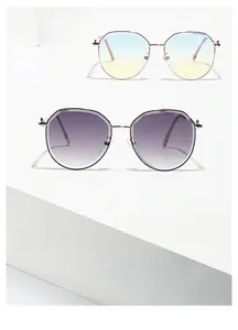 Detail of slim metal sunglasses with rose gold and silver frames and gradient lenses
