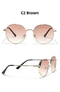 Detail view of round gold metal sunglasses with hollow design and tea gradient lenses