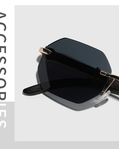 Close-up of frameless geometric sunglasses with gold metal hinges and dark lenses