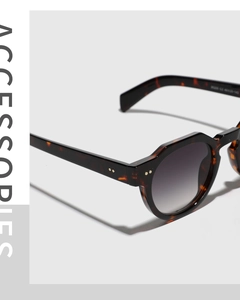 Macro view of tortoiseshell sunglasses frame with metal rivets and specifications