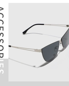 Close-up of silver metal hollow temples on cat-eye sunglasses with dark grey lenses