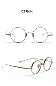 Macro detail of gold titanium round glasses frame showing metal bridge and nose pads