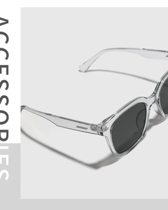 Close-up of transparent square frame sunglasses with silver rivet details and dark lenses