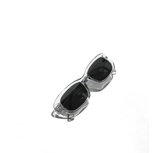 Modern rectangular sunglasses with clear frames and black lenses shown from a top-down view