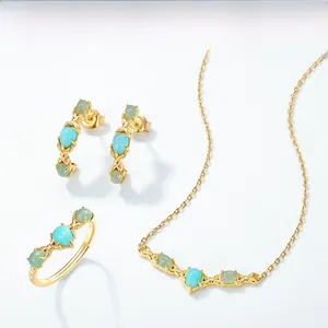 Close-up of elegant gold plated jewelry set with sky blue amazonite and green gemstones