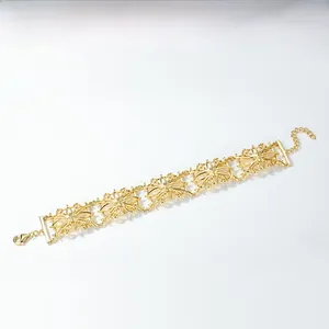 Detailed macro view of a gold-plated filigree hollow flower bracelet with lobster clasp