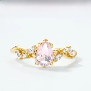 Detailed macro of a 18K gold-plated ring with a pear-shaped pink crystal and side diamonds