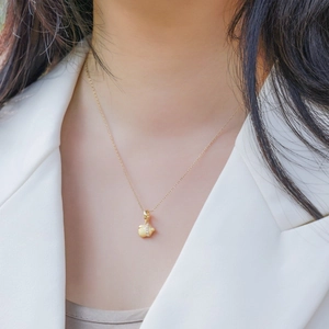 Collier pendentif biberon en argent S925 plaqué or avec zircons porté par un mannequin