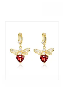 Detailed close-up of a golden bee earring with a heart-shaped red gemstone and crystals