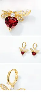Macro detail of bee earrings with S925 silver stamp and red garnet heart stones
