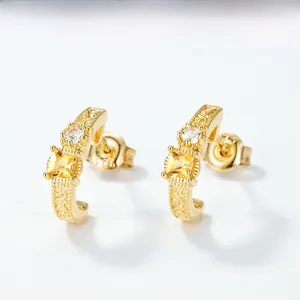 Macro detail of S925 sterling silver stamp and baroque patterns on gold-plated earrings