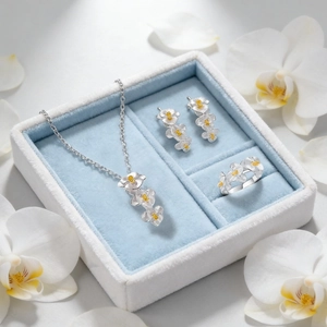 Elegant silver orchid jewelry set with necklaces and earrings in a blue velvet gift box