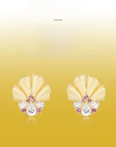 Detail of handmade brushed gold flower earrings with white and pink zircon crystals