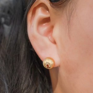 Handcrafted 925 silver studs with red garnet and gold brushed finish worn by a model