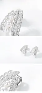 Macro detail of S925 silver earrings with pearls and cubic zirconia in lace pattern