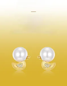 Close-up of duck pearl earrings with hand-brushed gold texture and diamond accents