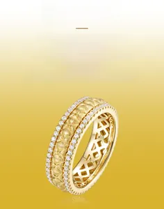 Macro detail of hand-brushed gold texture with side-set cubic zirconia on a spinner ring