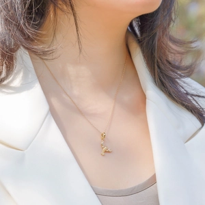 Elegant gold plated scorpion pendant necklace with sparkling crystals on a female model