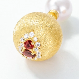 Gold brushed sphere stud earring with red garnet and a large white pearl backing