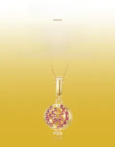 Detailed view of handmade brushed 18K gold pomegranate pendant with pink gemstones
