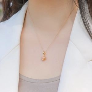 Elegant S925 sterling silver pomegranate necklace with pink stones worn on a model's neck