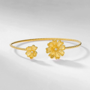 Minimalist gold floral open bracelet featuring a cable texture and sparkling crystals