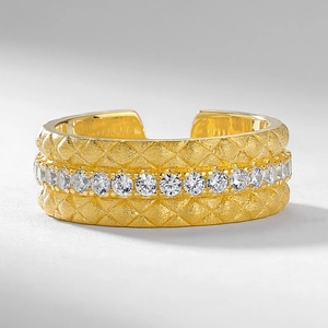 Anello aperto dorato con trama trapuntata, finitura spazzolata e zirconi brillanti