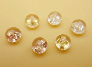 Macro detail of six clear silicone earring backs with internal golden metal clutch cores