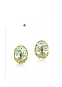 Détail de boucles d'oreilles ovales en cristal bleu clair avec bords dorés perlés
