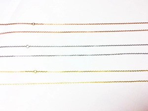 Vue macro détaillée de chaînes en maille forçat en finitions or, argent et rose