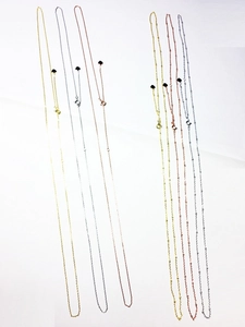 Détail de colliers en argent et plaqué or avec chaînes à billes et pendentifs en cœur