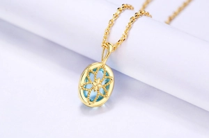 Vue macro du collier en argent S925 doré avec pendentif cristal bleu clair ajouré d'étoiles