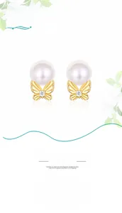 Detail of 18K gold butterfly pearl earrings with delicate wing texture and small diamond