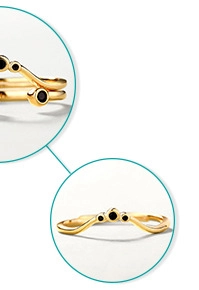 Detail of gold V-shaped crown ring featuring three round black stones for stacking