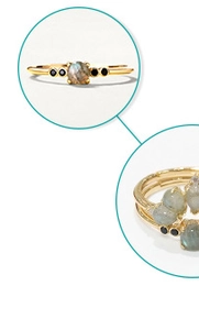 Detail of gold labradorite petal rings showing blue sheen and black gemstone accents