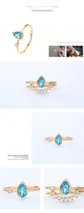 Detailed macro of a pear-shaped Swiss Blue Topaz and white zircon ring in gold finish