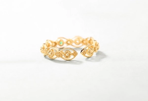 Detail eines Vintage-Spitzenrings mit smaragdgrünem Stein und Goldperlenrand