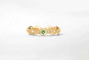 Detailaufnahme des Vintage-Spitzenrings in Gold mit smaragdgrünem Stein und weißen Zirkonen