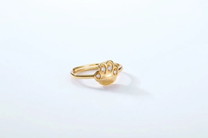 Macro detail of gold adjustable ring featuring a cute cat paw design with white zircons